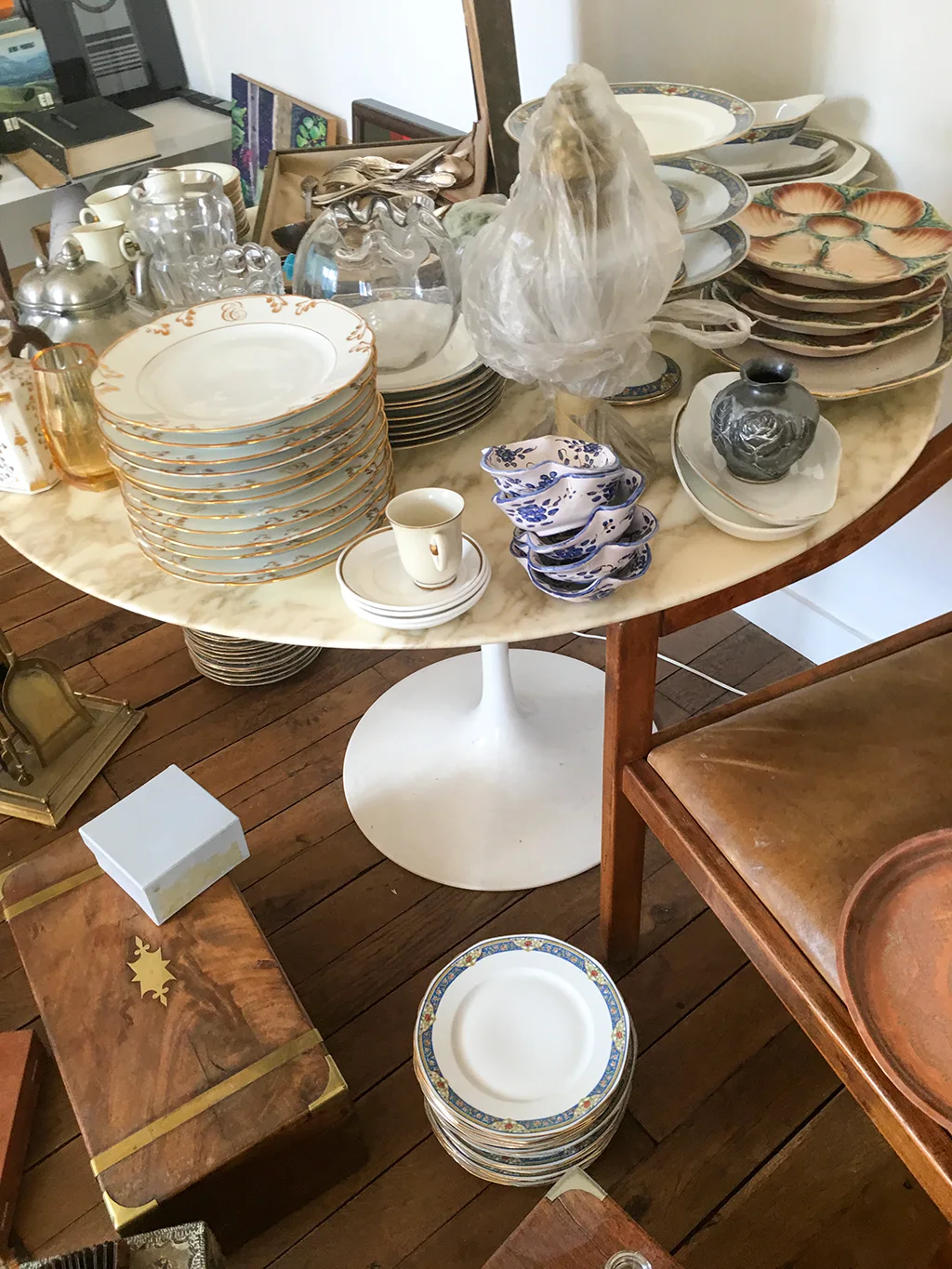 Table Knoll Saarinen plateau marbre chargée de vaisselle ancienne, porcelaines et céramiques, débarras de succession